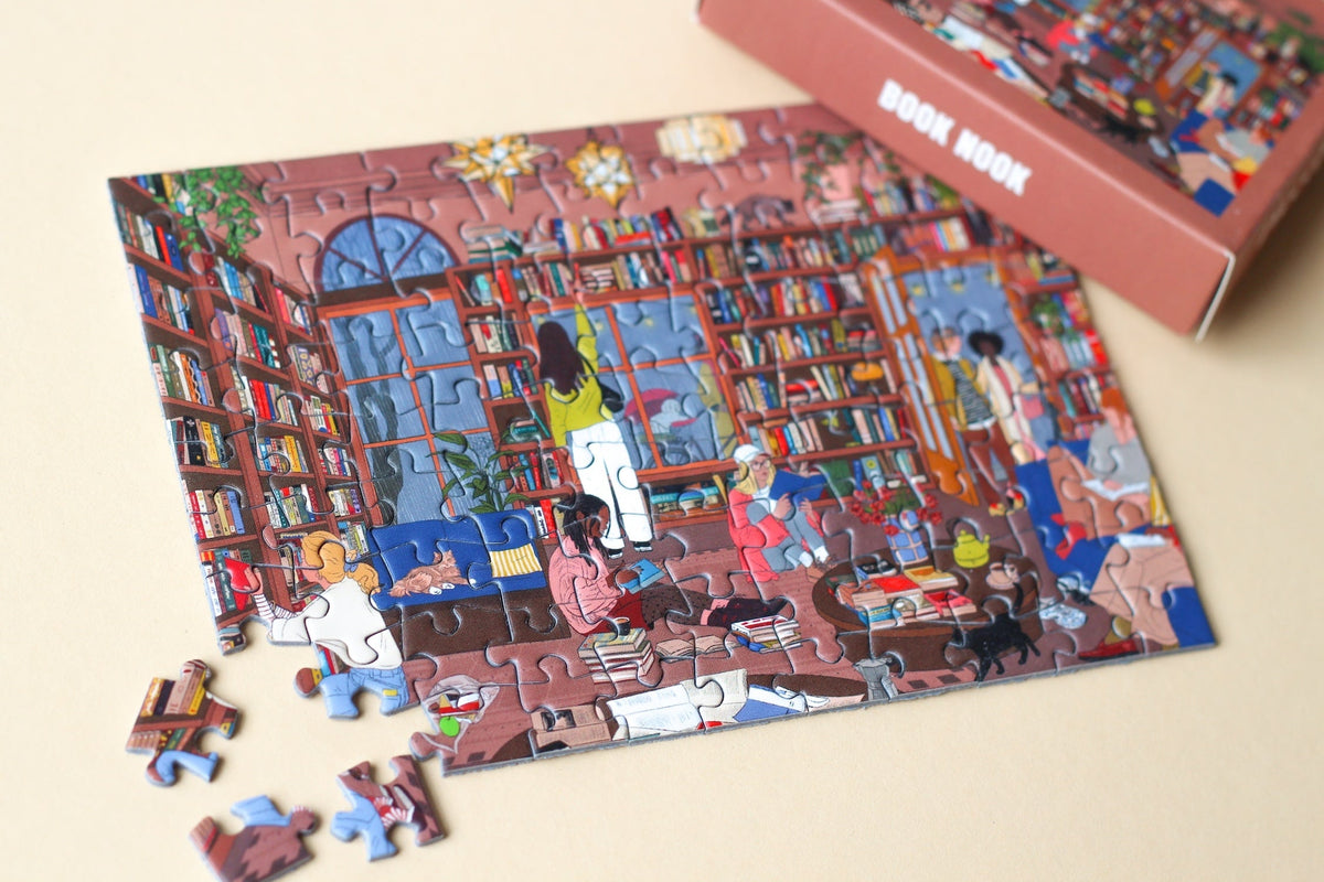 Fast fertig gelegtes Minipuzzle Book Nook mit einzelnen losen Teilen und Schachtel
