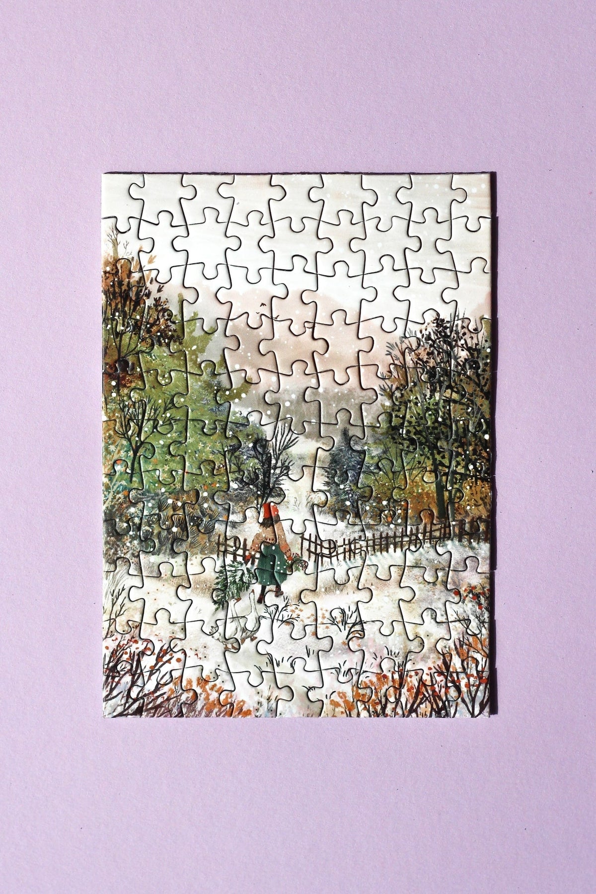 Fertig gelegtes Minipuzzle Homecoming mit Frau, Gänsen und verschneitem Weg zwischen Bäumen