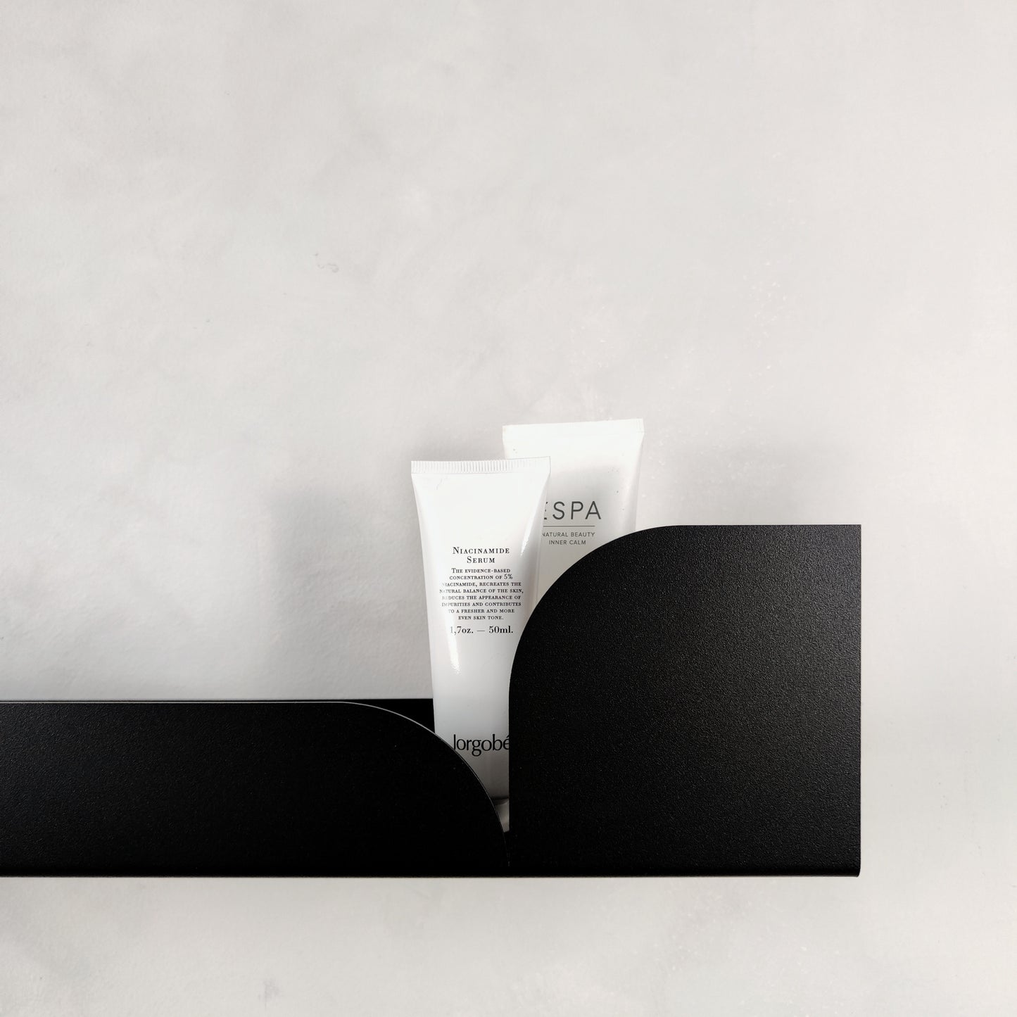 Minimalistisches schwarzes Wandregal aus Metall mit Pflegeprodukt