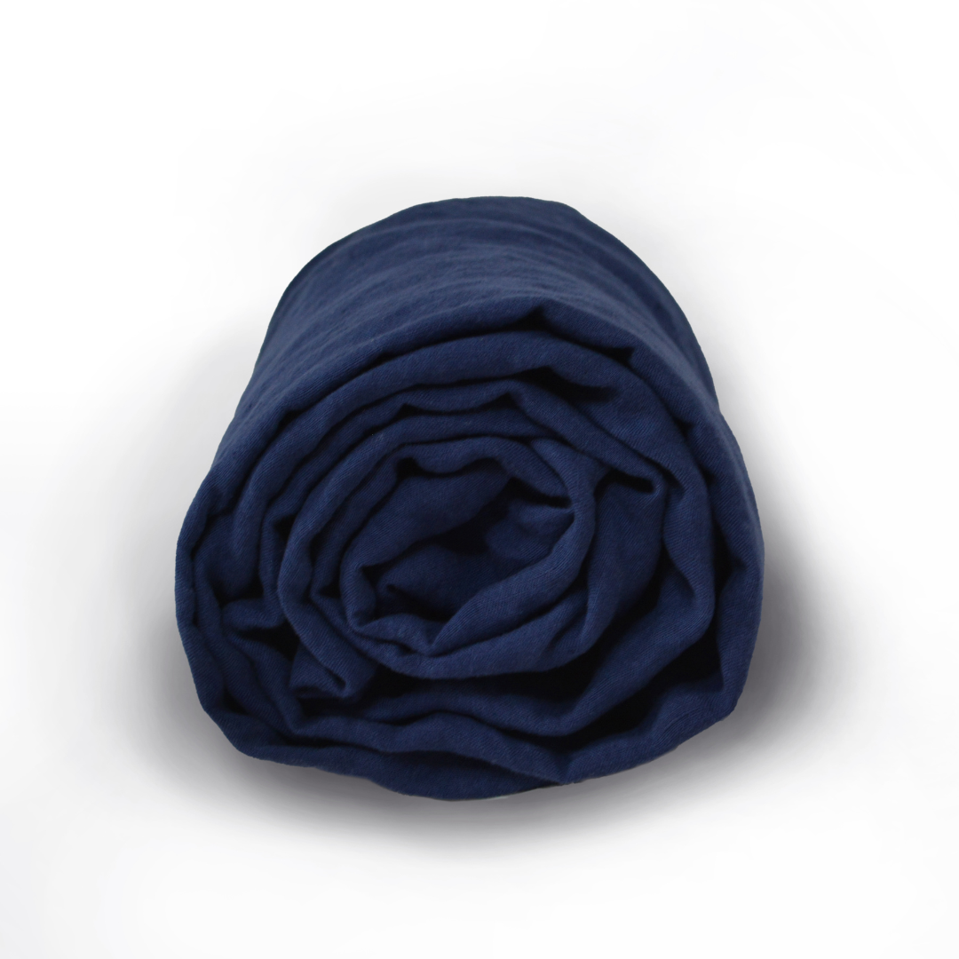 Spannbettlaken aus 100 % Hanf in der Farbe midnight blue, nachhaltig gefertigt, zusammengelegt auf weißem Hintergrund
