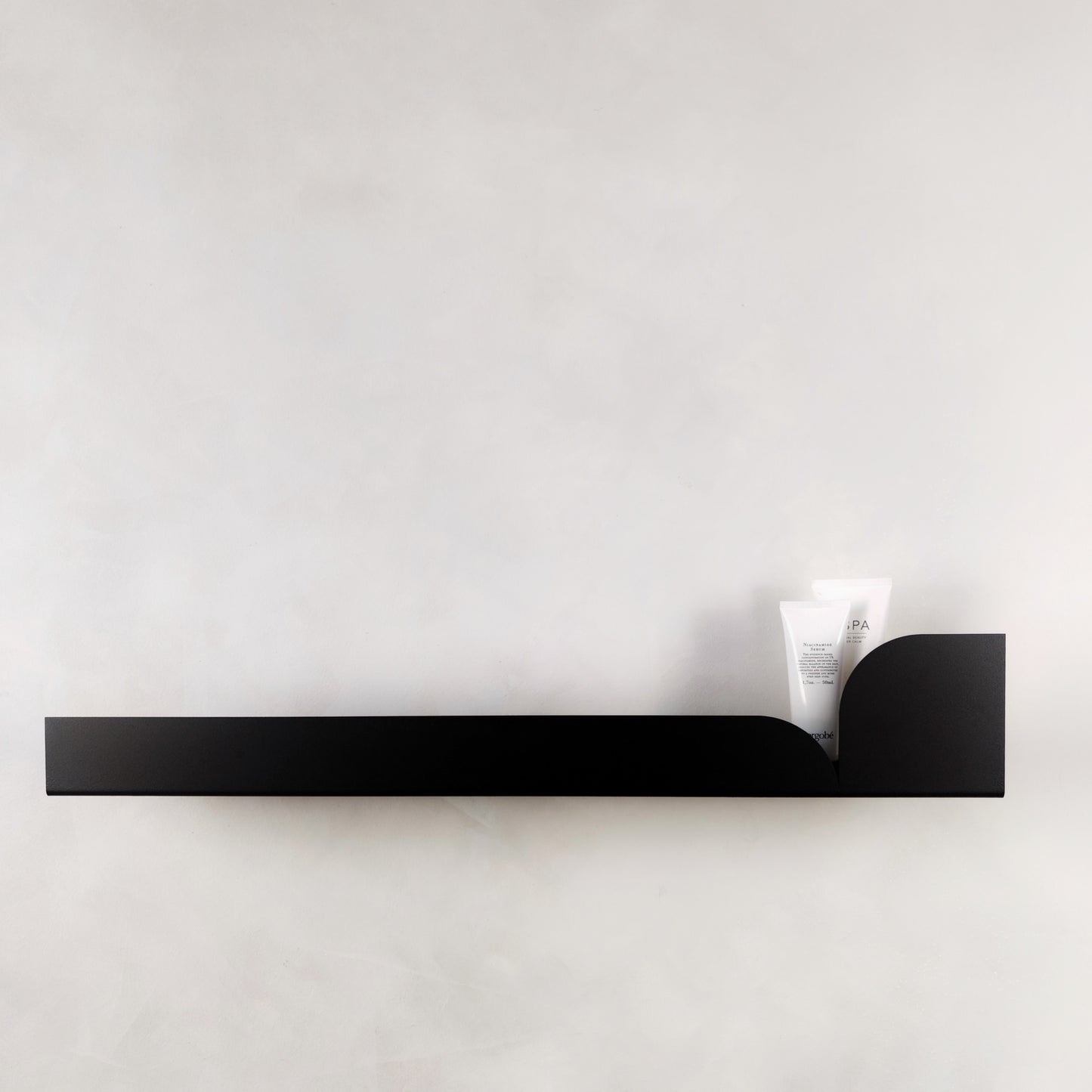 Langes schwarzes Metall Wandregal minimalistisch montiert an Wand