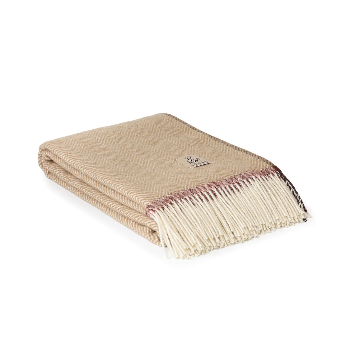 Gefaltete beige Decke mit hellem Zickzackmuster, kontrastierendem Rand und hellen Fransen
